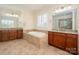 Bright bathroom features a soaking tub, dual vanities with granite counters, and plantation shutters at 9610 Pensive Ln, Waxhaw, NC 28173