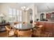 Bright dining area featuring hardwood floors, a modern chandelier and lots of natural light through shuttered windows at 9610 Pensive Ln, Waxhaw, NC 28173
