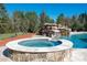 Backyard hot tub features a stone surround and is located near the pool and waterfall at 9610 Pensive Ln, Waxhaw, NC 28173