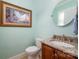A traditional powder room featuring a wood vanity and a round mirror at 9610 Pensive Ln, Waxhaw, NC 28173