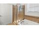 Bright bathroom showcasing a glass-enclosed shower and separate tub beneath a window at 103 Karlyn Ct, Mooresville, NC 28115