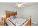Light-filled bedroom showcasing a stylish bed frame, a floral-patterned quilt, and a ceiling fan, creating a cozy retreat at 103 Karlyn Ct, Mooresville, NC 28115