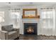 Close up of fireplace in living room, showcasing white mantle, mirror, and large window for lots of natural light at 103 Karlyn Ct, Mooresville, NC 28115
