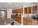 Well-lit kitchen with wood cabinets, stainless steel appliances, and tile backsplash and flooring at 103 Karlyn Ct, Mooresville, NC 28115
