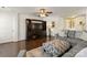 A view of the open-concept living room with dark wood floors, a ceiling fan, and an entertainment center with a large-screen television at 103 Karlyn Ct, Mooresville, NC 28115