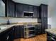 Kitchen featuring dark cabinets, granite countertops, and stainless steel double oven at 105 Timber Ridge Rd, Belmont, NC 28012