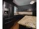 A renovated kitchen with stainless steel appliances, dark wood cabinets, and granite countertops at 105 Timber Ridge Rd, Belmont, NC 28012
