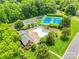 Aerial view of a pool, clubhouse, playground, and tennis courts surrounded by mature trees at 1102 High Brook Dr, Waxhaw, NC 28173