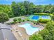 Aerial view of the community pool, tennis courts, and playground surrounded by lush greenery at 1102 High Brook Dr, Waxhaw, NC 28173