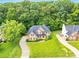 Aerial view of a beautiful brick home with lush landscaping, long driveway, and surrounded by mature trees at 1102 High Brook Dr, Waxhaw, NC 28173