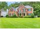 Beautiful brick home featuring manicured lawns, dark shutters and a welcoming covered entryway at 1102 High Brook Dr, Waxhaw, NC 28173