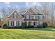 Charming two-story brick home with a lush, well-manicured lawn and manicured shrubbery at 1102 High Brook Dr, Waxhaw, NC 28173