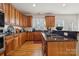 Beautiful kitchen featuring wooden cabinets, black appliances, hardwood floors, and countertops at 1102 High Brook Dr, Waxhaw, NC 28173