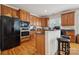Updated kitchen featuring wooden cabinets, black appliances, hardwood floors, and breakfast bar seating at 1102 High Brook Dr, Waxhaw, NC 28173