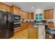Well-lit kitchen featuring stainless steel appliances, wooden cabinets, and a breakfast bar at 1102 High Brook Dr, Waxhaw, NC 28173