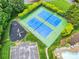 Overhead shot of blue and green community tennis courts and playground amidst a lush landscape at 1102 High Brook Dr, Waxhaw, NC 28173