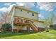 Spacious backyard featuring green grass, a wooden fence, and a wood deck attached to the back of the house at 11615 Hidden Grove Trl, Charlotte, NC 28215