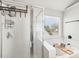 Bright bathroom featuring a shower with glass door, and a soaking tub with a view at 11615 Hidden Grove Trl, Charlotte, NC 28215