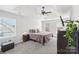 Light-filled bedroom with a tray ceiling, ceiling fan, carpet, and multiple windows at 11615 Hidden Grove Trl, Charlotte, NC 28215