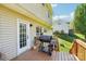 View of the house's wood deck featuring a grill, a door to the house, and a view of the grassy backyard at 11615 Hidden Grove Trl, Charlotte, NC 28215