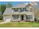 Charming two-story home featuring a well-manicured lawn and attached garage at 11615 Hidden Grove Trl, Charlotte, NC 28215