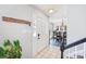 Bright foyer with tile flooring, a coat rack, and a view of the dining room with elegant chandelier at 11615 Hidden Grove Trl, Charlotte, NC 28215