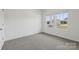 An empty bedroom featuring neutral carpet and two windows with a view of the front yard at 1234 Morehead Dr, Salisbury, NC 28144