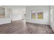 Open-concept living room with wood-look floors, ample natural light from windows, and seamless flow into the kitchen at 1234 Morehead Dr, Salisbury, NC 28144