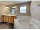 Bathroom with a large tub, double sinks, and luxury vinyl plank flooring at 1240 Periwinkle Dr, Waxhaw, NC 28173