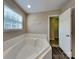 Bathroom with a large tub, vinyl plank flooring and natural lighting at 1240 Periwinkle Dr, Waxhaw, NC 28173