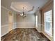 Elegant dining room features laminate floors, a tray ceiling, and a chandelier at 1240 Periwinkle Dr, Waxhaw, NC 28173