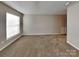 Spacious living room featuring neutral walls, plush carpeting, and natural light from a large window at 1240 Periwinkle Dr, Waxhaw, NC 28173