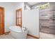 Bright bathroom features a soaking tub with a window view and a tiled walk-in shower at 127 Castle Dr, Mooresville, NC 28117