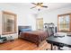 Cozy bedroom with hardwood floors, ceiling fan, desk, and natural light from two windows at 127 Castle Dr, Mooresville, NC 28117