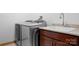 Modern laundry room with stainless steel washer/dryer, granite countertop, and wooden cabinets at 127 Castle Dr, Mooresville, NC 28117