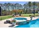 Pool area featuring hot tub, fire pit, and lounging area at 127 Castle Dr, Mooresville, NC 28117