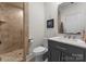 Bathroom featuring a tiled walk-in shower with glass door, a vanity with marble top, and modern fixtures at 127 N Tryon St # 615, Charlotte, NC 28202