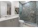 Modern bathroom boasts walk-in shower with glass door and blue accent tiles, along with a vanity and marble countertop at 127 N Tryon St # 615, Charlotte, NC 28202