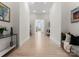 Bright hallway with hardwood floors, white walls, and decorative art leading to a well-lit living space at 127 N Tryon St # 615, Charlotte, NC 28202