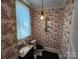 Small bathroom featuring a pedestal sink, toilet, and decorative wallpaper at 146 Saluda St, Chester, SC 29706