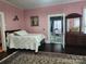 Charming bedroom featuring ensuite bathroom, floral accents, wood floors, and antique dresser at 146 Saluda St, Chester, SC 29706
