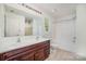 Bathroom featuring double sink vanity, large mirror, tub, and shower combo providing plenty of comfort at 15619 Lakepoint Forest Dr, Charlotte, NC 28278