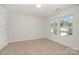 Well-lit bedroom with two windows, plush carpet, and ample natural light to enjoy a relaxing space at 15619 Lakepoint Forest Dr, Charlotte, NC 28278