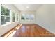 Well-lit open living area featuring hardwood floors and a wall of windows at 15619 Lakepoint Forest Dr, Charlotte, NC 28278