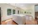 Bright living room with hardwood floors, white cabinets, a central island, and an abundance of windows at 15619 Lakepoint Forest Dr, Charlotte, NC 28278