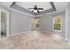 Spacious main bedroom features a tray ceiling, two bright windows, and neutral carpet at 1720 Chamberside Dr, Rock Hill, SC 29730