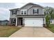Charming two-story home with gray siding, brick accents, and a spacious two-car garage at 1986 Paddlewheel Dr, Stanley, NC 28164
