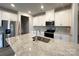 Modern kitchen featuring white cabinets, stainless steel appliances, and a granite countertop island at 1986 Paddlewheel Dr, Stanley, NC 28164
