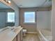 This bathroom features a bathtub and shower combo, vanity, tile flooring and natural light at 2122 Shumard Cir, Indian Trail, NC 28079