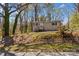 Tan home with black trim situated on a beautiful tree-filled lot with a small front porch at 216 E Georgia Ave, Bessemer City, NC 28016